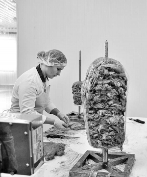 Працівниця фабрики ”Країна смаку” в селі Бугрин Рівненської області готує кебаб-донер, аналог турецької шаурми. Із 90 робітників там переважно жінки