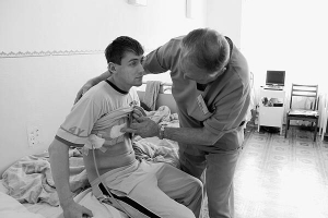 Лікар Михайло Соболь оглядає порізаного Андрія Кибу у Хмельницькій міській лікарні. Тепер загрози життю чоловіка немає