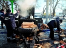 Еменесники рубають дрова для польової кухні, яку відкрили біля Львівського залізничного вокзалу