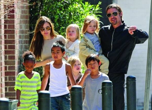 Американські актори Анджеліна Джолі і Бред Пітт під час прогулянки Лос-Анджелесом несуть на руках двійнят Нокса і Вів’єн. Між ними йде син Шайло. Зліва направо прямують всиновлені Захара з Ефіопії, Меддокс із Камбоджі і Пакс із В’єтнаму