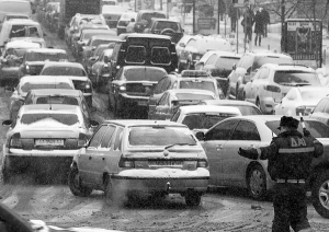 Інспектор працює на дорозі в Києві, де утворився затор у вівторок увечері. Проблеми з рухом були майже по всьому місту. Основною причиною стали понад сто дрібних аварій через снігопад