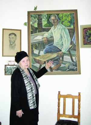 Ужгородка Марія Чендей біля картини, на якій зображений її чоловік — письменник Іван Чендей