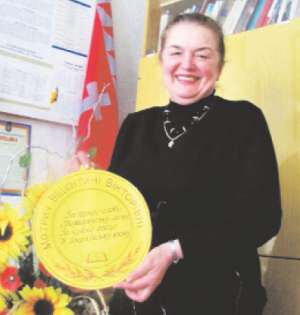 Директор Вінницької школи №5 Віцентина Мотрич показує саморобну паперову медаль, яку їй подарували колишні учні під час зустрічі випускників