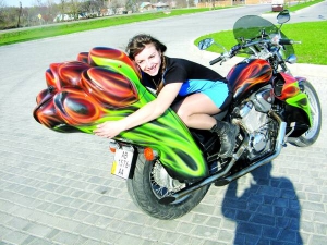 Ірина Репей із міста Гайсин на Вінниччині обіймає багажник свого мотоцикла ”Хонда Стід”. Його переробив для неї хрещений Олександр Нечепуренко у подарунок на 8 Березня