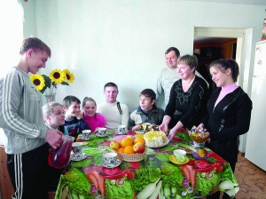 Ольга Копиця (друга праворуч) накриває на стіл обідати. Варить для родини 5-літрову каструлю борщу. Щодня дає дітям солодощі