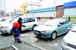 Паркувальник на столичній вулиці Дегтярівській допомагає водієві заїхати на стоянку. Вона тут коштує сім гривень за годину