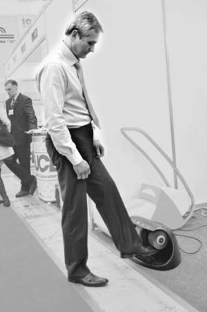 Директор  фірми ”Тетра Україна” Володимир Мильков у  столичному Виставковому центрі показує апарат для чистки взуття ”Гойте”. У дорогих готелях такі машинки працюють безплатно. У торговельних центрах за чищення просять 5 гривень