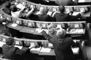 У сесійній залі нардеп-”регіонал” Михайло Чечетов піднятою рукою догори показує більшості голосувати за поправки до Кримінального процесуального кодексу. 11 квітня