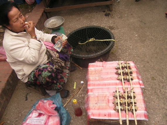 Местная женщина торгует мясом на палочках