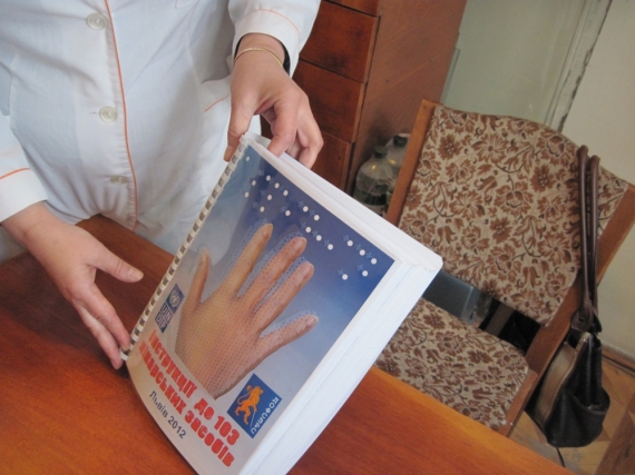 Генеральний директор Львівської обласної аптечної асоціації тримає книгу-інструкцію для незрячих