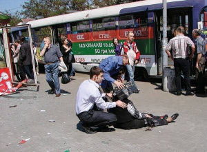 Люди допомагають пораненій жінці біля зупинки на перехресті проспекту Карла Маркса й вулиці Сєрова в Дніпропетровську. Там 27 квітня об 11.40 пролунав перший із чотирьох вибухів. Стався саме тоді, коли під'їхав трамвай
