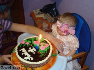 Мама дає доньці задути свічку на торті &quot;Кутузов&quot;