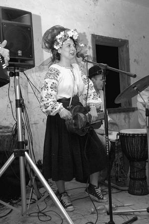 Ярина Квітка з гурту ”Фолькнери” співає та грає на колісній лірі на танцях в клубі у мистецькому хуторі Обирок на Чернігівщині