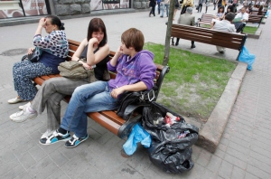 Люди сидят у пакета с мусором, который заменил традиционную урну. Ул. Крещатик, Киев