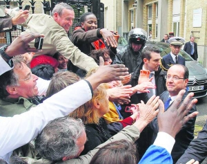 Новообраний глава Франції — Франсуа Олланд тисне руки своїм прихильникам у Парижі в день своєї інавгурації в середу. Він пообіцяв бути ”нормальним президентом”, не ховатися у Єлисейському палаці, а ходити на інтерв’ю та зустрічі з виборцями. Його кортеж на церемонію їхав у загальному потоці й зупинявся на всіх світлофорах