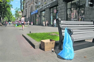 У центрі Києва на вулиці Хрещатик замість бетонних урн поставили картонні коробки, а до лавок прив’язали поліетиленові пакети. Перехожі ними не користуються, викидають сміття собі під ноги