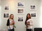 Девушки позируют возле своих фото на выставке Колобова