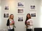 Дівчата позують біля своїх фото на виставці Колобова