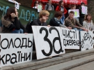 Учасники першого українського маршу Тиші з плакатами сидять на сходах біля Європейської площі