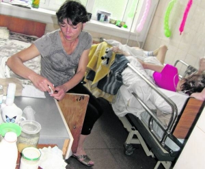 Алла Гудзь, мати Олександри Попової, чергує в її палаті в Миколаївській лікарні швидкої допомоги. Праворуч на ліжку спить Олександра. Коли прокидається, крутиться і намагається встати