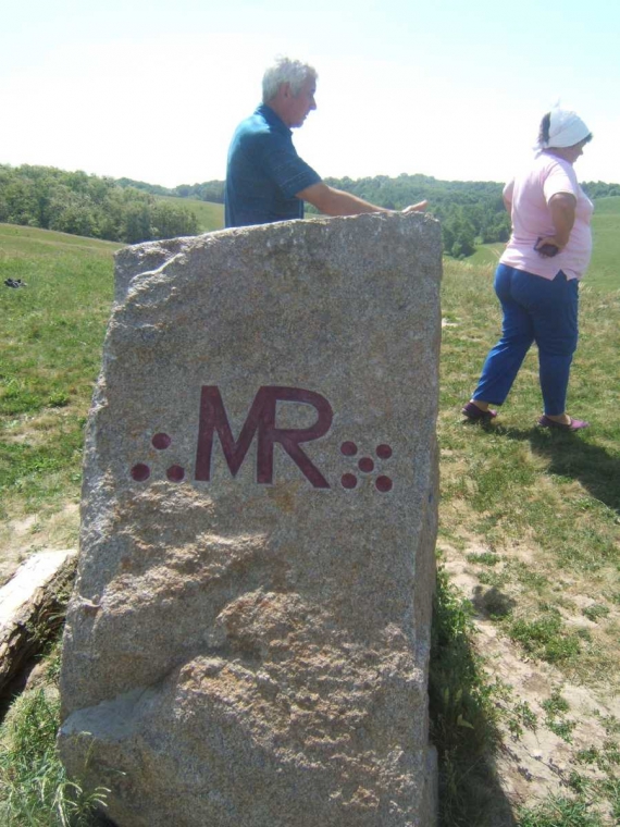 На горі стоїть камінь із вибитими літерами MR, що означають &quot;владика вогню&quot;