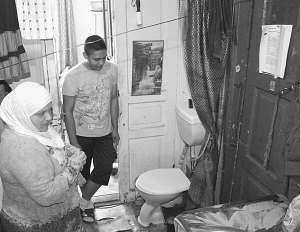 Вінничанка Жасмин Аль-Гурані із сином Миколою стоять біля унітаза поряд із вхідними дверима. 
Його встановили торік на кухні