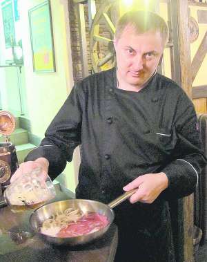 Шеф-кухар Олег Білоус заливає світле пиво у сковорідку з підсмаженими цибулею та м’ясом