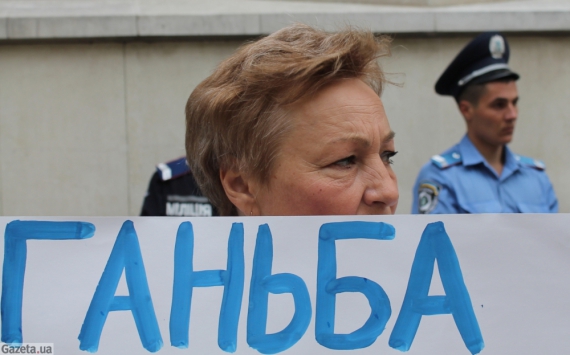 Участница митинга держит плакат с надписью &quot;Позор Марине Ставнийчук за ее редакцию 2450!&quot;