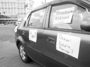 Один з автомобілів, що припарковані біля Українського дому в Києві. Мітингувальники обклеїли їх закликами до власників забрати автівки. Бо вважають, що машини пригнали правоохоронці, щоб перекрити заїзд до будівлі