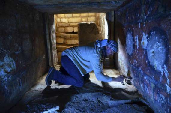 Археолог расчищает пыль в погребальной камере