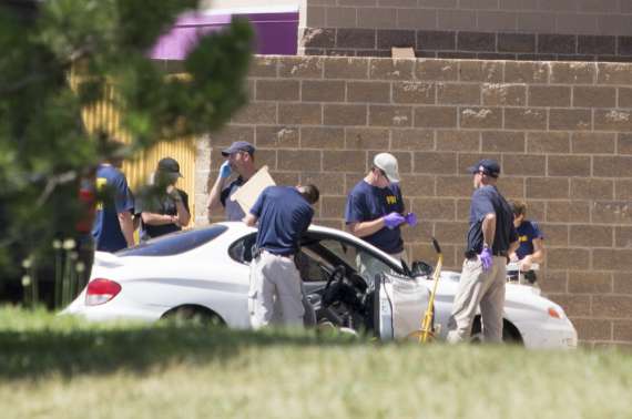 Полиция осматривает автомобиль подозреваемого 24-летнего Джеймса Игана Холмса