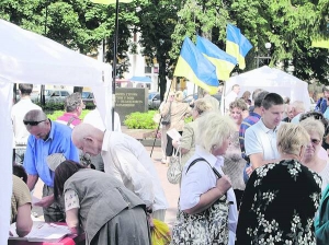 Жителі Чернігова в агітаційних наметах опозиції ставлять підписи під позовом проти президента Віктора Януковича. 25 липня