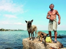 Феодосієць Юрій Забоєв зі своїми собаками – трирічною Гайною та її тримісячним цуценям Леді – купаються в морі біля місцевого порту