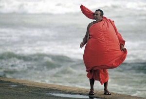 Буддійський монах стоїть на березі Індійського океану
