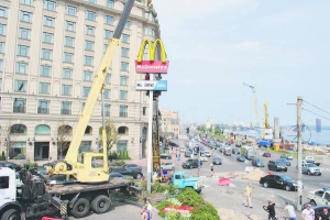 Робітники ”Київавтодору” знімають вивіску біля ”Макдональдзу” на столичній Поштовій площі. На час реконструкції тут не працюватиме ”Макдрайв” — частина закладу, де водії купують їжу, не виходячи з авто