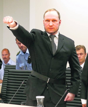 Норвезький терорист Андерс Брейвік піднятою вгору і затисненою у кулак рукою вітає присутніх у залі суду перед оголошенням вироку. На талії має пасок зі скобою, до якої чіпляють наручники