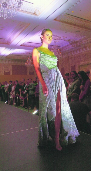 Модель у зеленій сукні з круїзної колекції дизайнера Сергія Єрмакова дефілює подіумом у столичному готелі ”Фермонт”. Плаття коштує понад дві тисячі доларів, бо пошите з елітних тканин