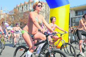 Киянка Марина Гернер (ліворуч) їде велосипедом по столичному Хрещатику. Жінка на шостому місяці вагітності. Перед тим, як узяти участь у змаганнях, порадилася з чоловіком