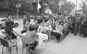 На тротуарі біля будинку уряду сидять військовослужбовці у відставці та звільнені в запас з родичами. Прийшли протестувати проти виселення із гуртожитків та квартир. 19 вересня