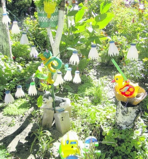 У дворі дев’ятиповерхівки в Черкасах квітник прикрасили іграшками та фігурно вирізаними пластиковими пляшками