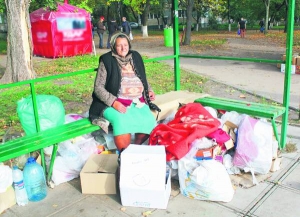 Лідія Дуравіна сидить на зупинці на Південній Борщагівці в Києві. У картонних коробках і пакетах зберігає речі та їжу. Брудний одяг ходить прати до родички. Її клунки займають півзупинки
