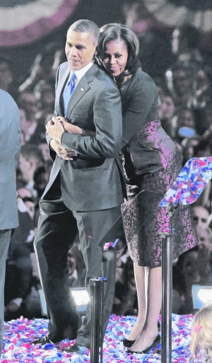 Перша леді США Мішель Обама обіймає чоловіка Барака Обаму після його переможної промови у Чикаго 6 листопада