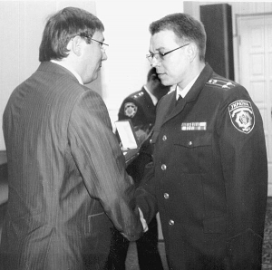 Міністр внутрішніх справ Юрій Луценко (ліворуч) за розкриття резонансного злочину нагороджує підполковника міліції Олександра Товпигу нагрудним знаком ”Закон і честь”. Фото 2009 року. Зараз обоє засуджені