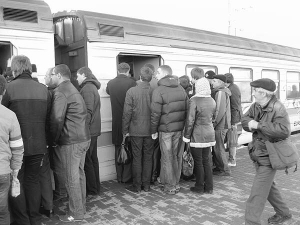 Люди пробиваються до вагона міської електрички на станції ”Троєщина-2” уранці 7 листопада в Києві. Коли з технічних причин один із потягів не приїхав за графіком, на платформі зібралися понад півтисячі осіб. Вони близько двох годин не могли сісти через тисняву