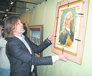 Російський художник Нікас Сафронов тримає одну зі своїх картин, які привіз у Донецький обласний художній музей. Загалом на виставку взяв 80 робіт