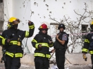 Ізраїльські пожежники стоять на місці падіння палестинської ракети