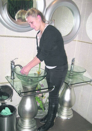 Полтавка 19-річна Катерина Володько миє руки у вбиральні ”Кіото-бару”. У раковини кладуть пелюстки троянд