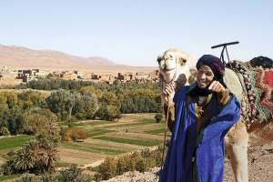 Марокканець пропонує прогулянку на верблюді поблизу гори Джебель