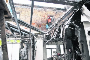 Працівники жеку розчищають дах шестиповерхового будинку на столичній вулиці Мазепи, 3. Уночі 21 листопада тут згоріли вісім квартир. Замість даху будинок накрили поліетиленовою плівкою, щоб всередину не падав сніг