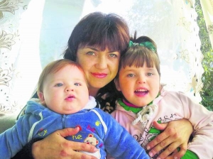 Тетяна Паршакова тримає на руках дітей 4-річну Станіславу та 1,5-річного Арсена. Для обстеження їхнього мозку в ізраїльській клініці потрібні майже 30 тисяч доларів